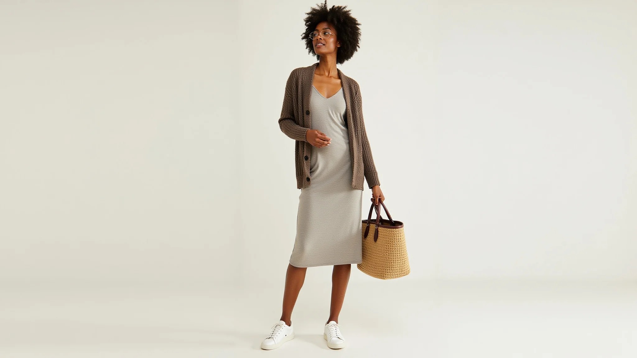 Look com vestido midi, casaco de tricô e tênis.