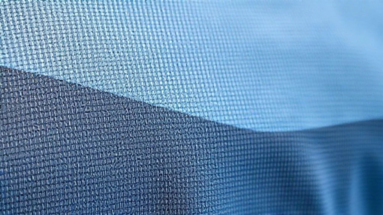 Detalhe de tecido esportivo respirável, poliéster/elastano, absorção de suor.