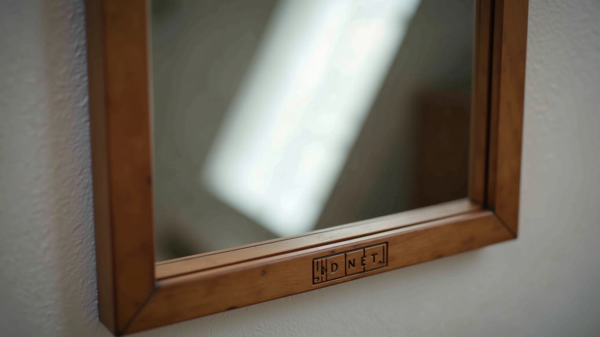 Detalhe da moldura de couro de um espelho Adnet com foco nítido.