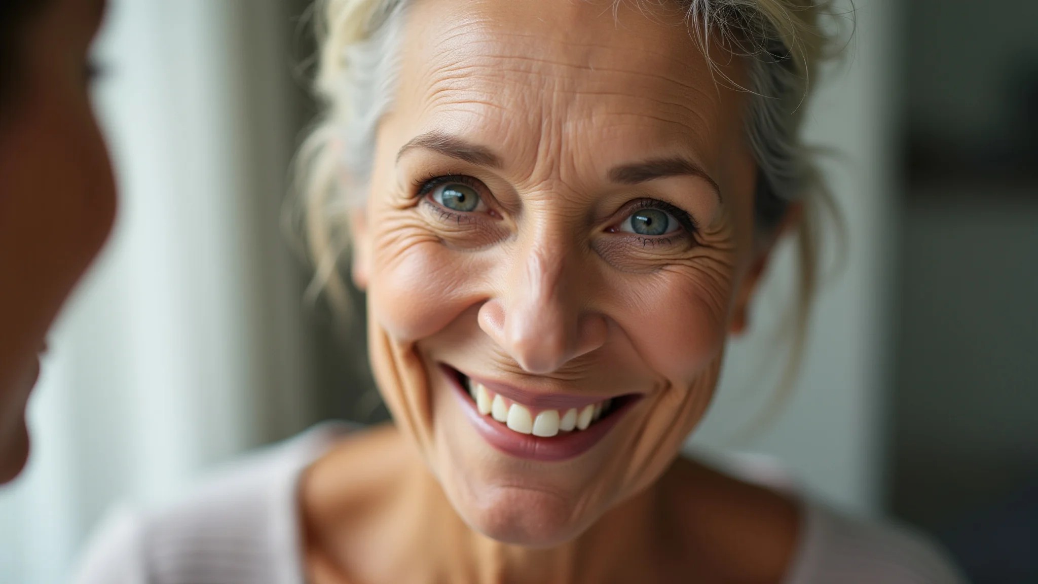 Mulher de 60 anos aplicando maquiagem leve, realçando sua beleza natural com um sorriso gentil.
