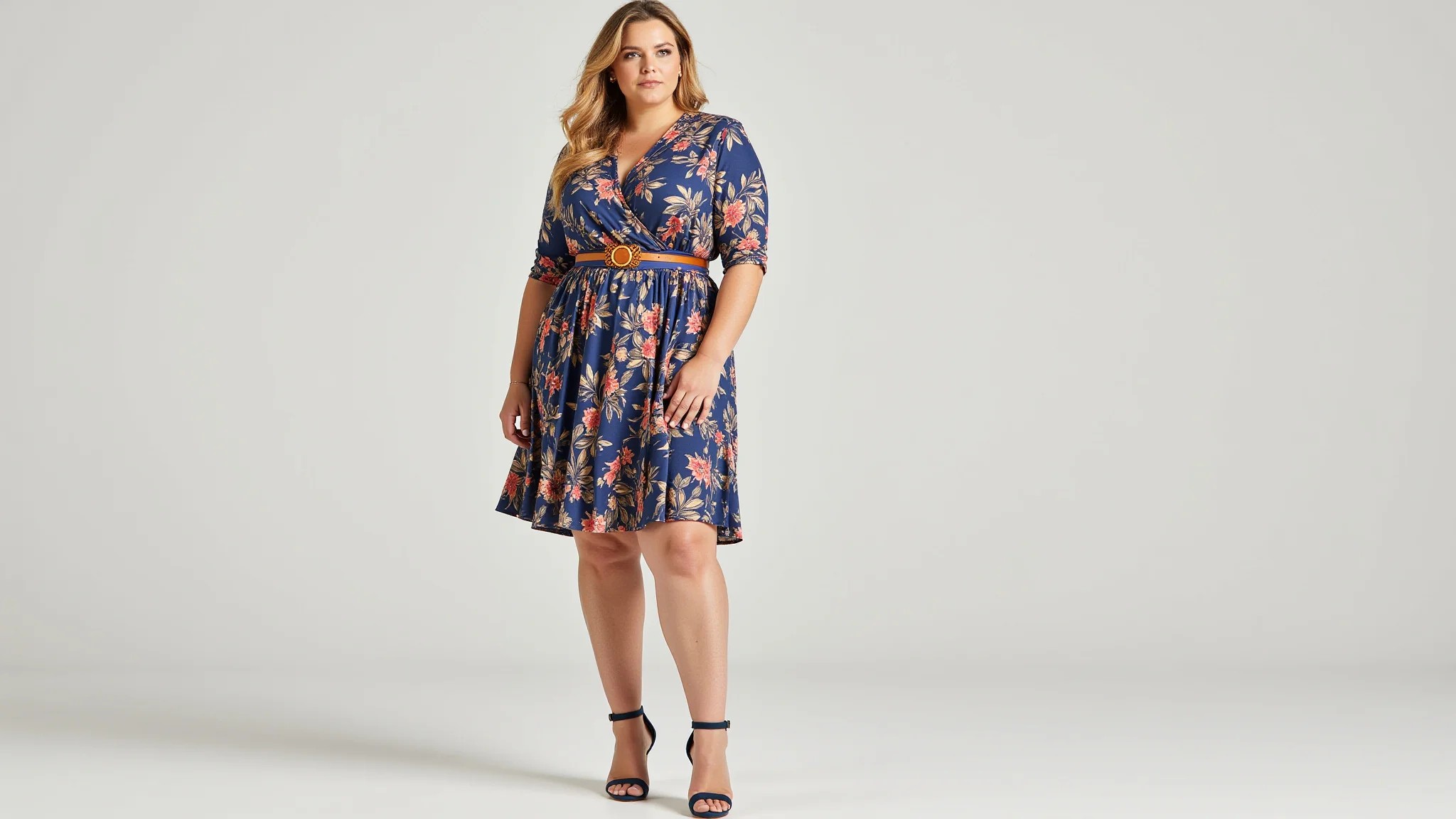 Mulher plus size com vestido corte A e cinto, realçando a silhueta.