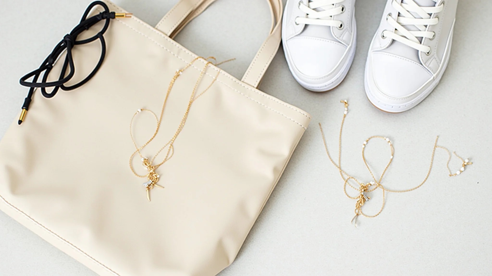Sugestão de presente minimalista: colar delicado, tênis branco e bolsa tote.
