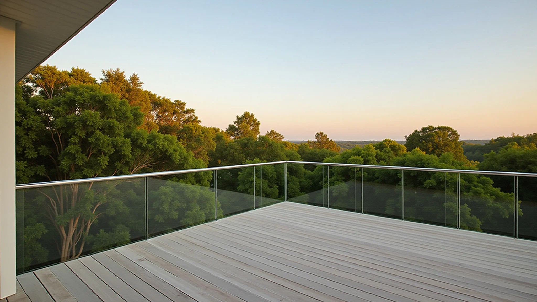 Deck externo com guarda-corpo de vidro sem moldura e vista para paisagem verde.