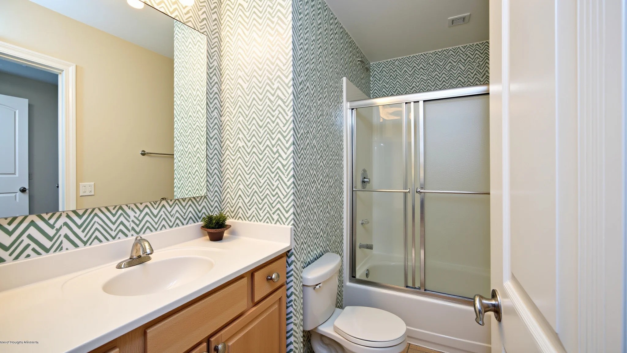 Lavabo pequeno com papel de parede estampado e iluminação clara.