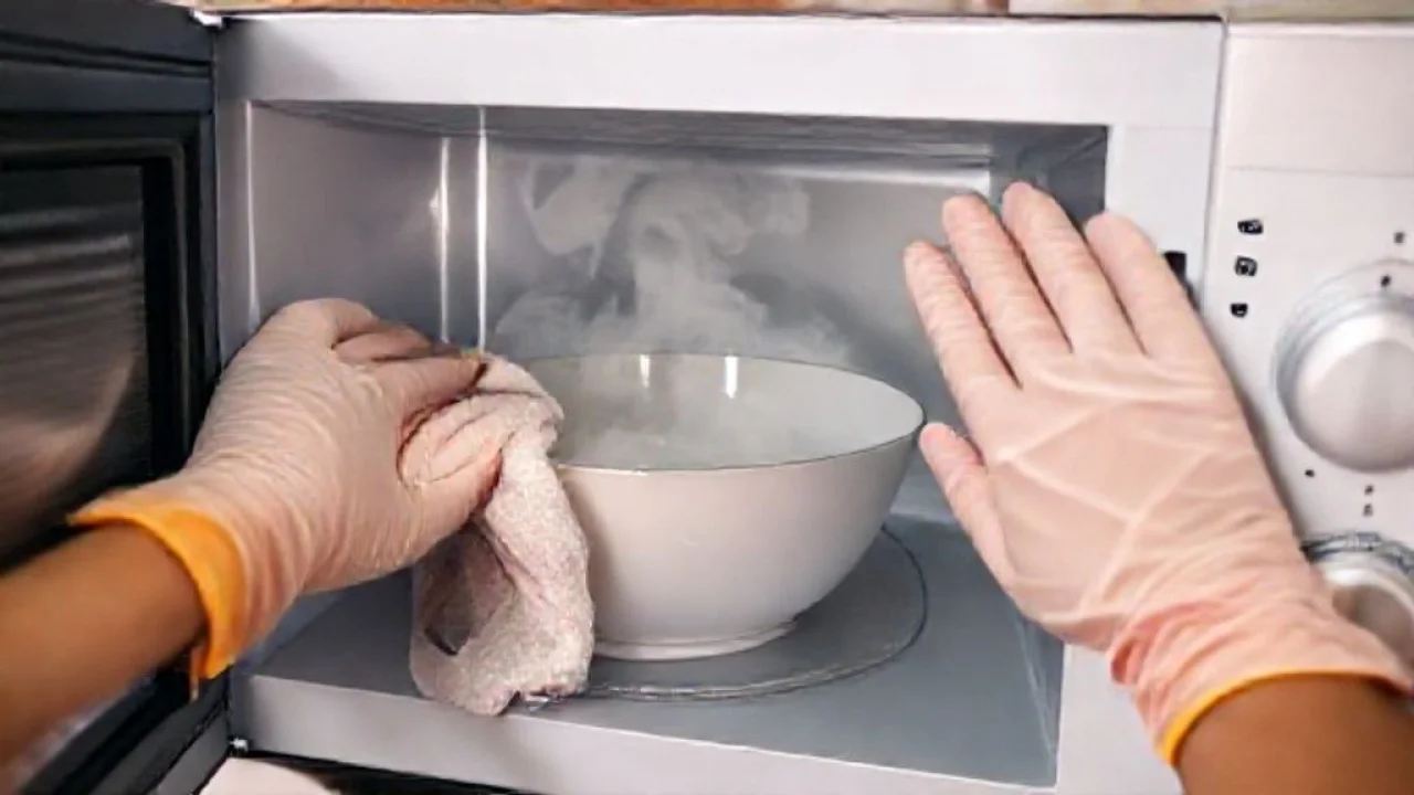 Limpando o micro-ondas com pano úmido após o vapor