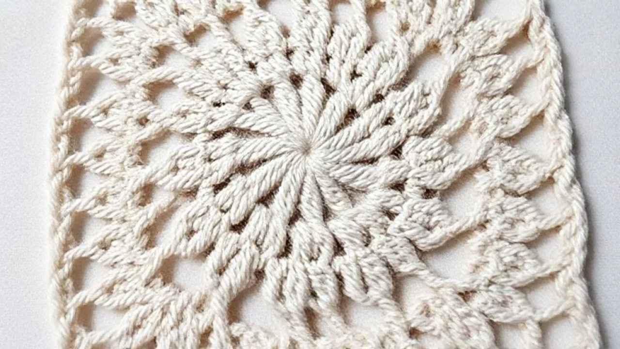 Close-up of a handmade crochet square, showcasing the intricate pattern and texture, soft natural Detalhe macro de um quadrado de crochê feito à mão, mostrando a textura e o padrão intrincado dos pontos.