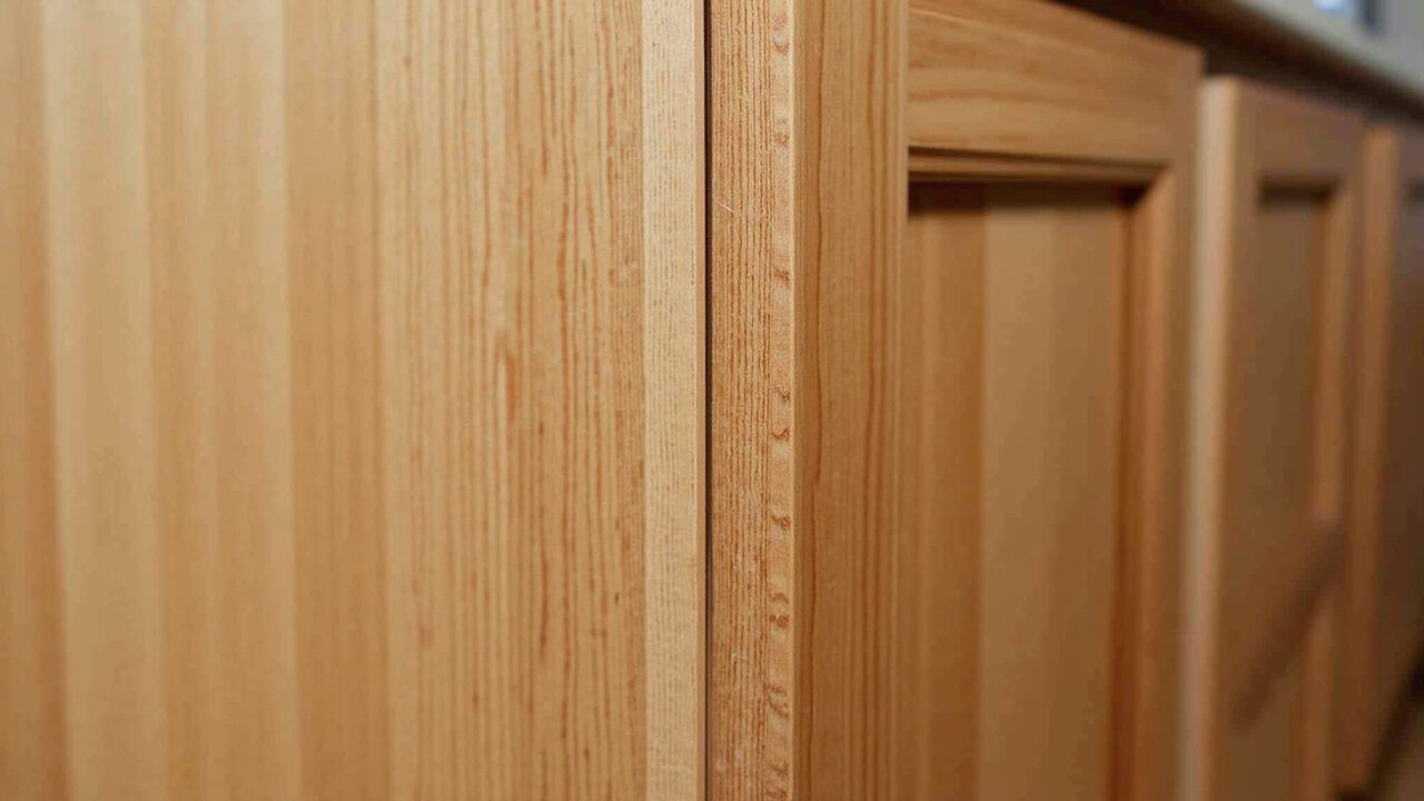 Close-up of solid wood kitchen cabinet, showing wood grain, durable finish, professional lighting, Detalhe da madeira maciça de um armário de cozinha, mostrando sua durabilidade.
