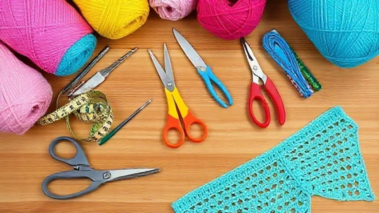 Selection of crochet hooks, colorful cotton yarns, scissors, measuring tape, and stitch markers Materiais para crochê: agulhas, fios coloridos, tesoura e marcadores. Artesanato.
