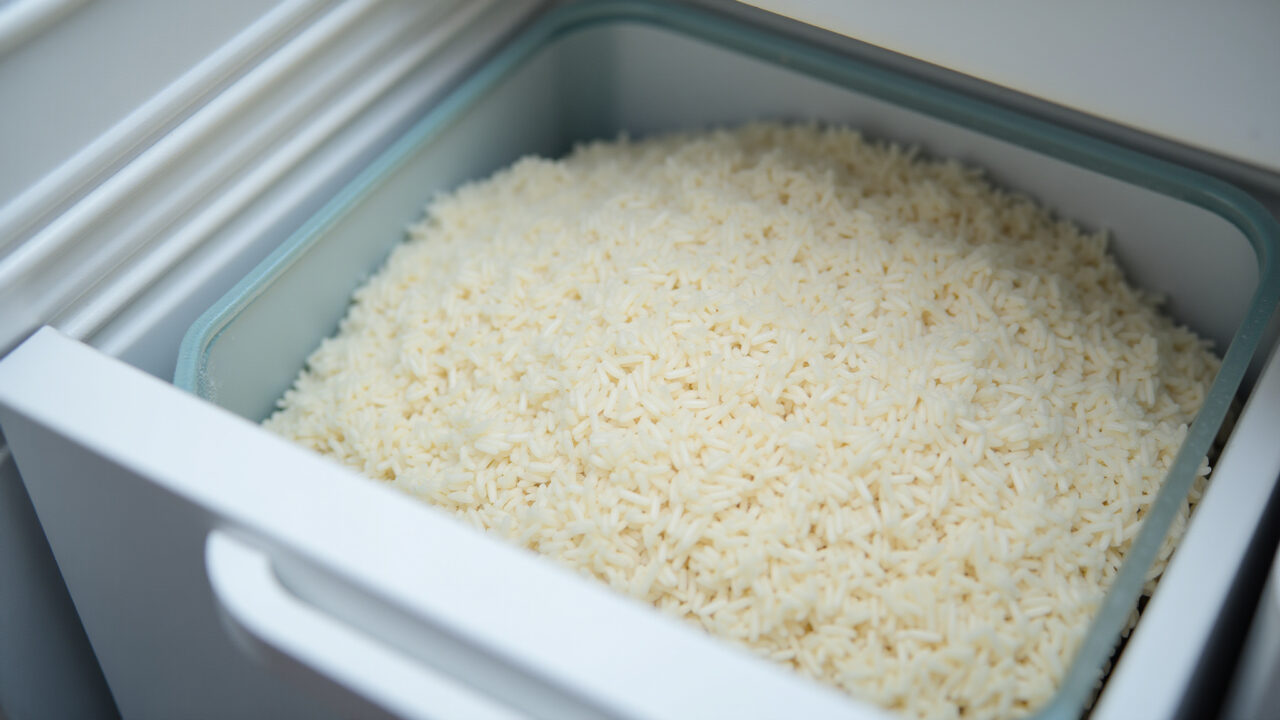Freezer with container of frozen rice, food preservation, concept of freezing rice, 8k, Arroz cozido congelado em um recipiente no freezer.