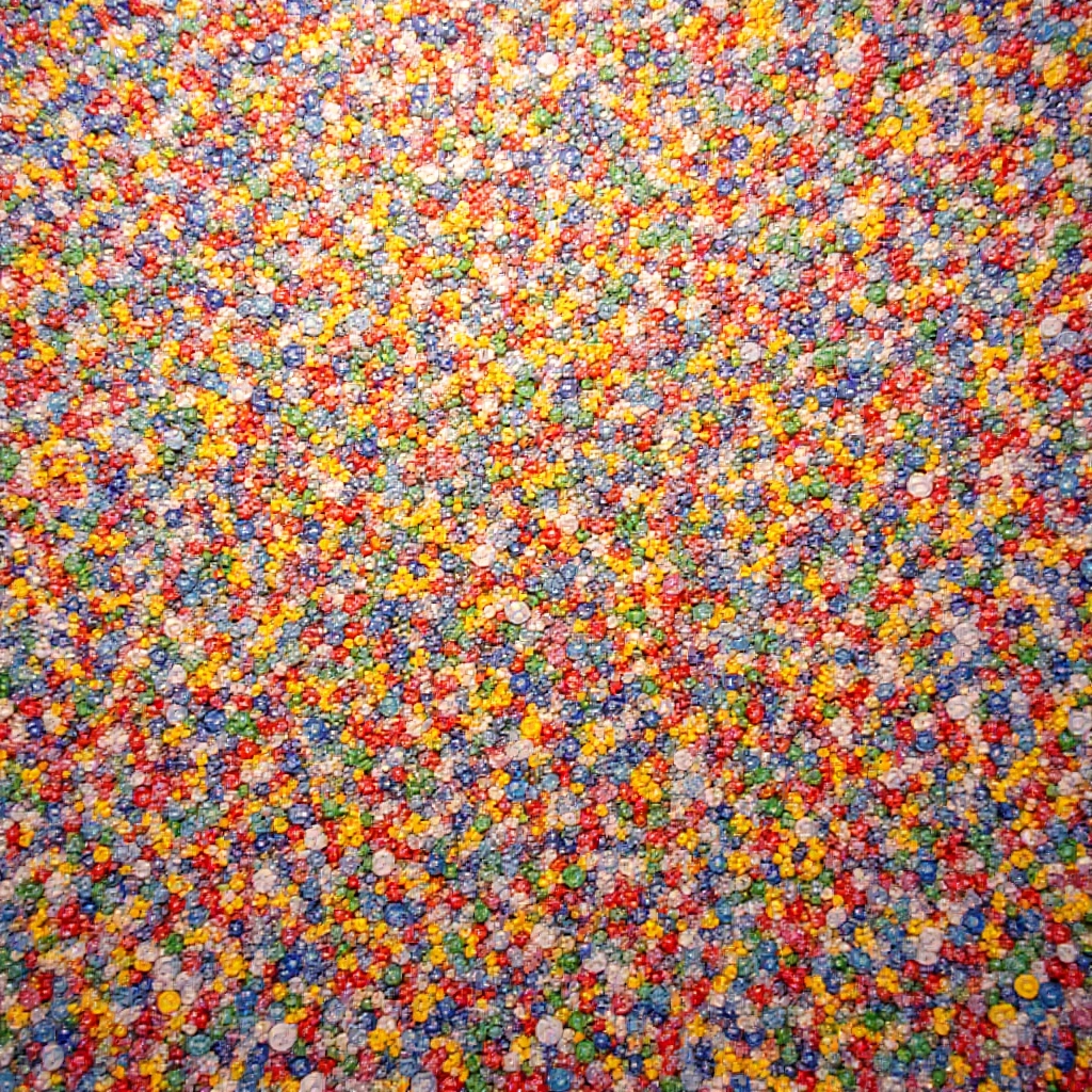 Painel de mosaico feito com tampinhas de garrafa, com cores vibrantes e design abstrato.