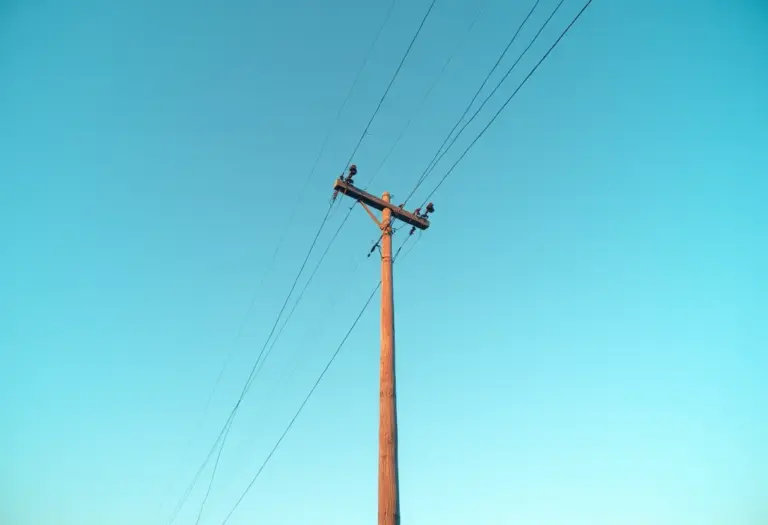 Poste de luz alto contra o céu azul ao entardecer.